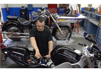 person working on a motorcycle in a garage
